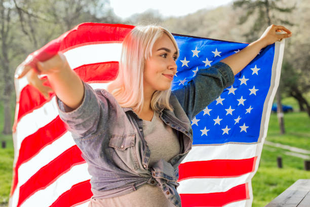 istock Girl flying American flag on wind 663661106