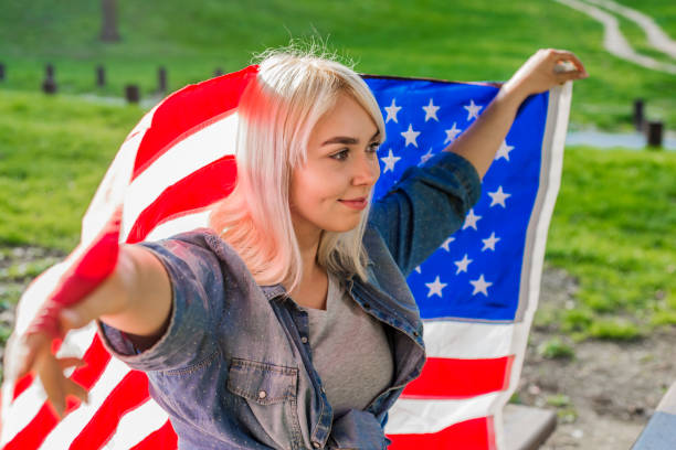 istock Woman holding an American flag 663661210
