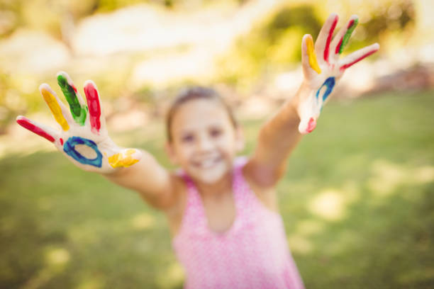 istock Little girl stretching out her painted hands 663790812