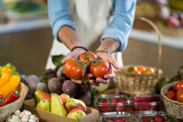 istock Vendor offering tomatoes at the counter 663793990