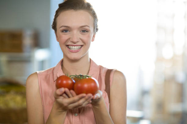 istock Woman holding tomatoes in grocery store 663794392