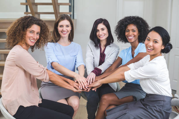 istock Female business colleagues putting their hands together 663800978