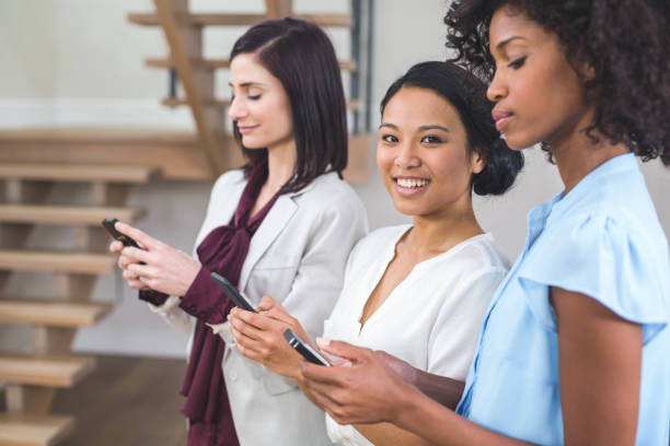 istock Happy female business colleagues using mobile phone 663803698