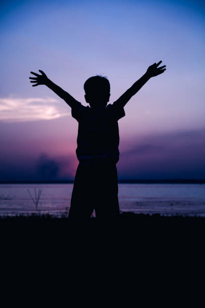 istock Silhouette of child enjoying at riverside. 663806664