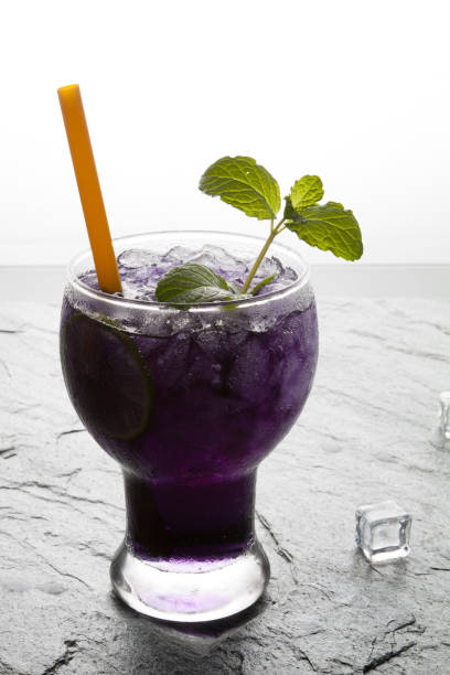 istock Purple soda lime drink with lime on stone. 663813262