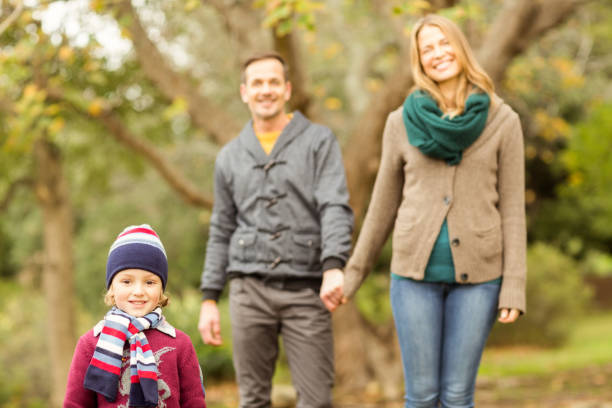 istock Smiling young family walking together 663828016