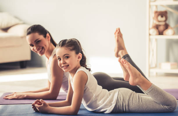 istock Mom and daughter doing yoga 663828064