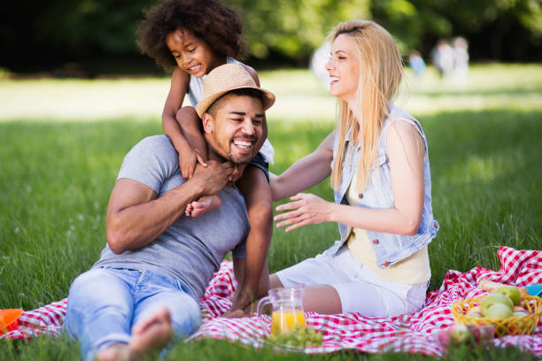 istock Family having fun and smiling while  picnicing in nature 663828342