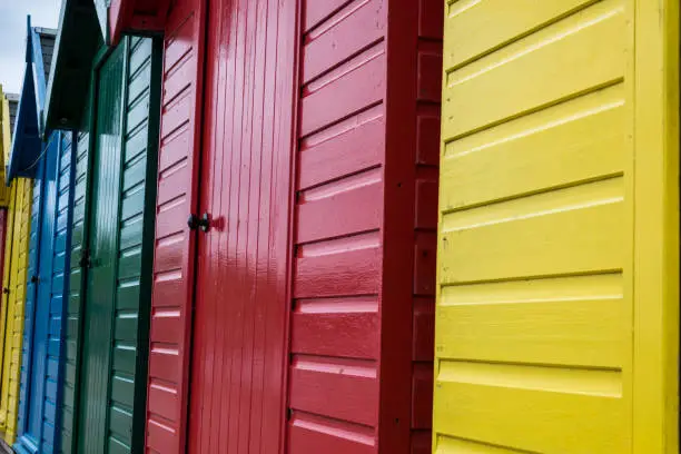 Row of beach huts in different colours - blue,red,green and yellow