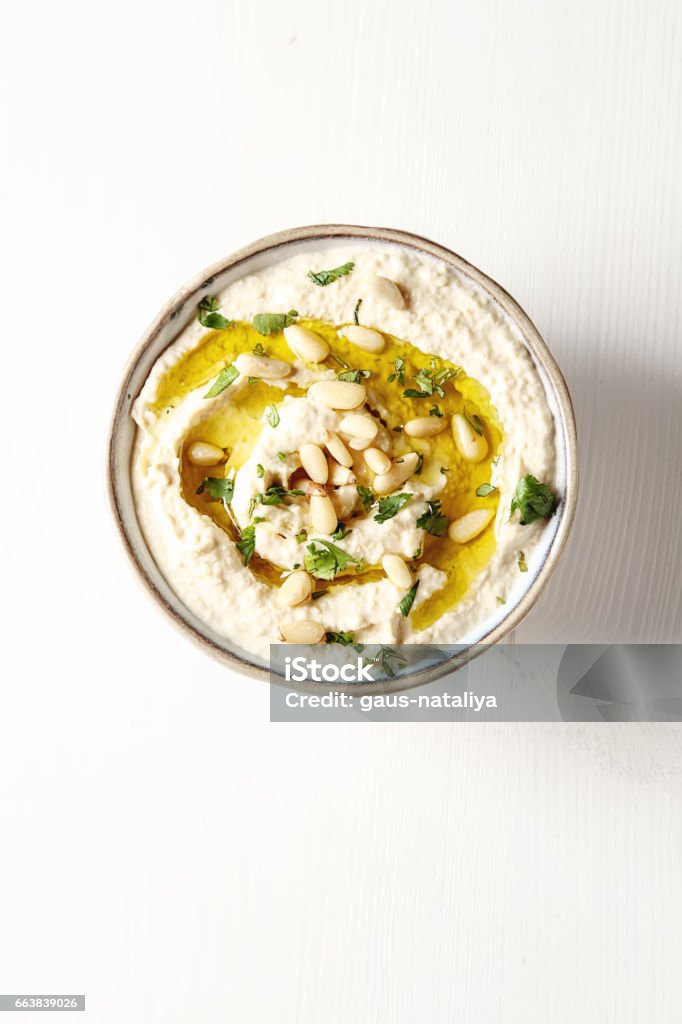Classic hummus with herbs, olive oil in a vintage ceramic bowl. Traditional Middle Eastern cuisine. Light white background. Classic hummus with herbs, olive oil in a vintage ceramic bowl. Traditional Middle Eastern cuisine. Light white background Appetizer Stock Photo
