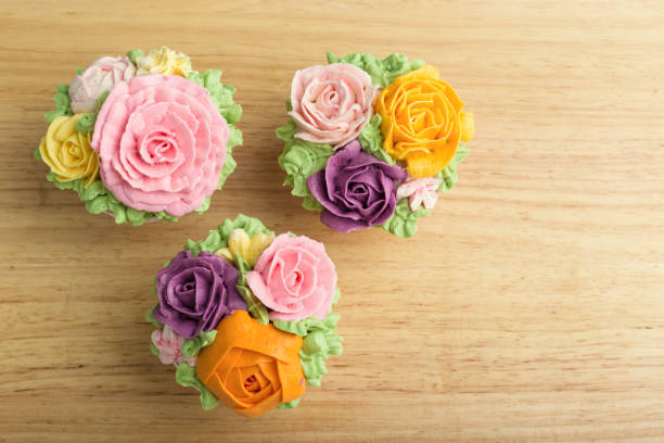 Delicious creamy cake with flowers - on wooden background