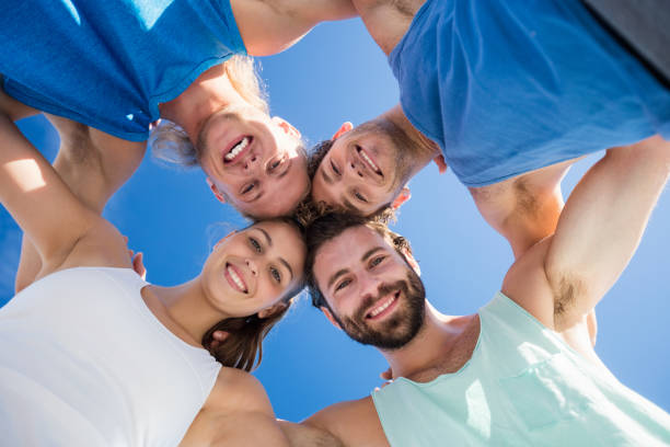 Friends putting their heads in a circle on the beach
