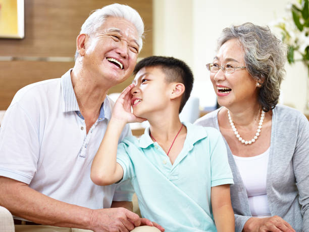 abuelos y nieto que se divierten - whispering grandparent child grandfather fotografías e imágenes de stock