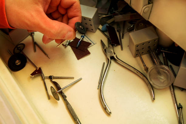 istock Hand is holding dental tools. Dental prosthesis, dentures, prosthetics work. Dental technician in process of making dentures. Hand is holding dental tools. Stomatology. 663845254