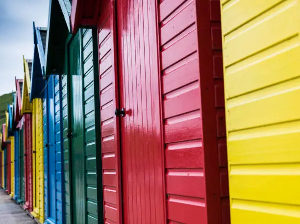 Row of beach huts in different colours - blue,red,green and yellow