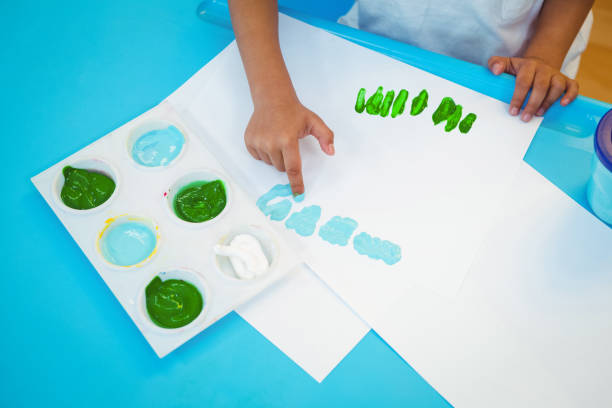 istock Girl using her fingers to paint 663845982