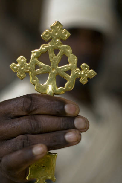 Golden Lalibela cross. LALIBELA, ETHIOPIA - CIRCA AUGUST 2007 - A Priest shows off a golden cross. Each rock hewn church has its own unique cross that is are said to be priceless. UNESCO have take care of all the churches ensuring the crosses are safe and secure at all times. the church of saint george lalibela ethiopia stock pictures, royalty-free photos & images
