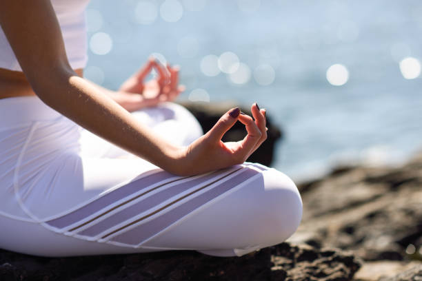 istock Young woman doing yoga in the beach 663852242