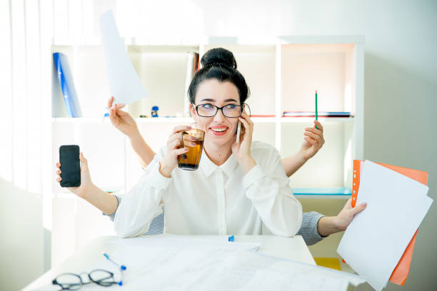 Successful businesswoman multitasking A successful businesswoman is multitasking in office versatility stock pictures, royalty-free photos & images