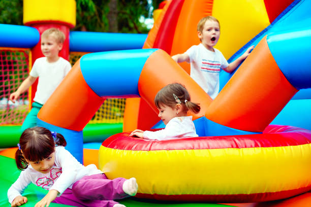 niños felices, divirtiéndose en el parque de atracción inflable - inflatable child playground leisure games fotografías e imágenes de stock