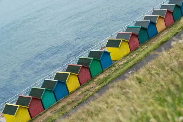 Row of beach huts in different colours - blue,red,green and yellow