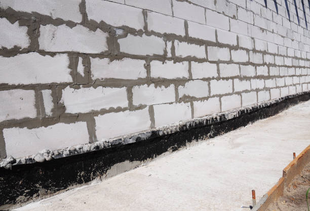 istock Waterproofing and insulation house  foundation wall. Waterproofing house foundation with bitumen membrane. 663859150