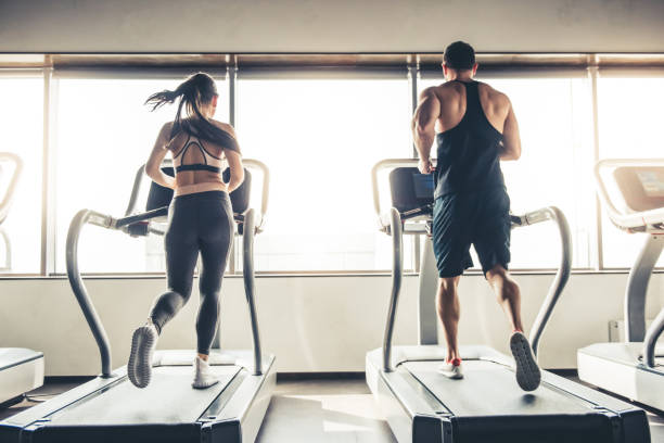 At the gym Back view of beautiful sports people running on a treadmill in gym cardiovascular exercise stock pictures, royalty-free photos & images