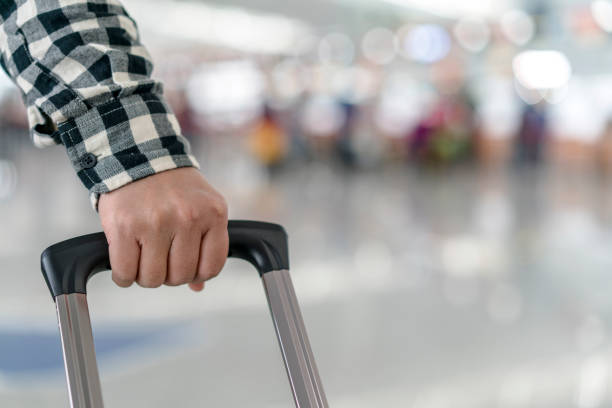 istock traveler pulling luggage in airport terminal 663860174