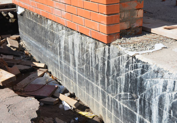 istock Waterproofing foundation house wall. Foundation Waterproofing and Damp proofing Coatings.Waterproofing house foundation with spray on tar. Construction site  for waterproofing basement and foundations 663863414