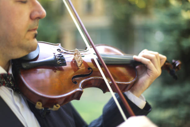 istock Man playing violin outdoors 663867436