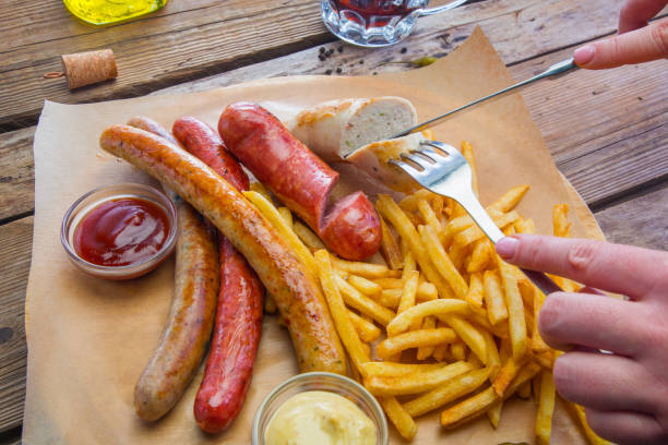 istock Hands is cutting a knife and fork fatty sausages 663870742