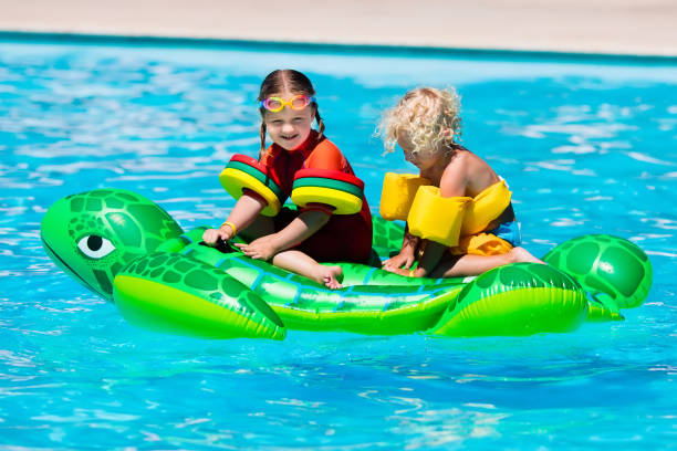 istock Kids in swimming pool with inflatable toy 663887754