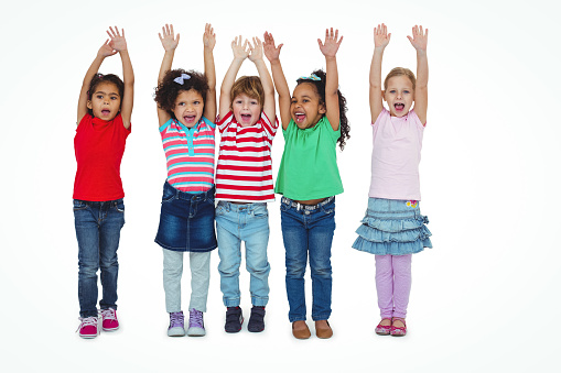 Small group of kids standing together with arms raised against a white background
