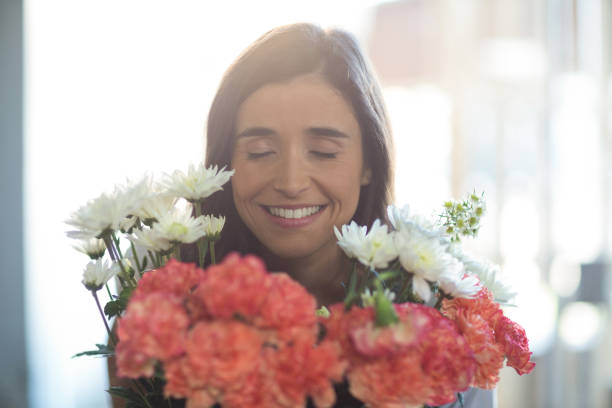 istock Smiling woman holding a bouquet with eyes closed 663894730