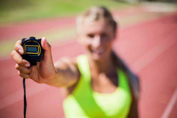 istock Female athlete showing stop watch 663894912