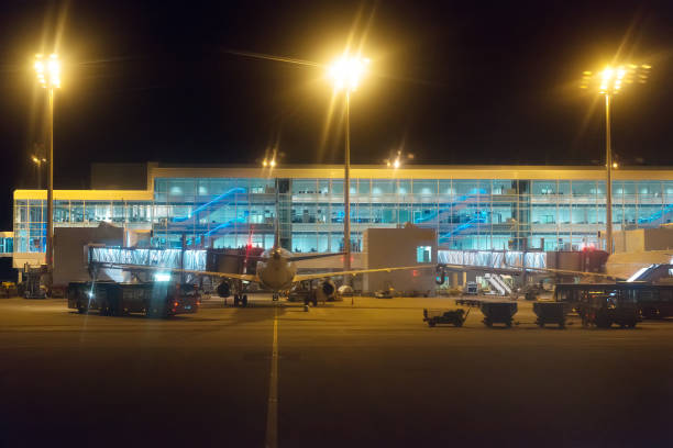 istock Passenger plane and busses at night airport. 663898596