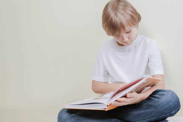 istock Little kid reading a book. Education, school, leisure concept 663901256