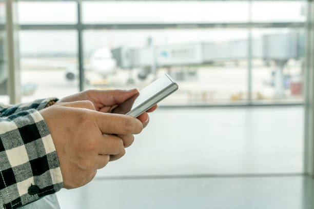 istock hand holding mobile phone in airport 663901366