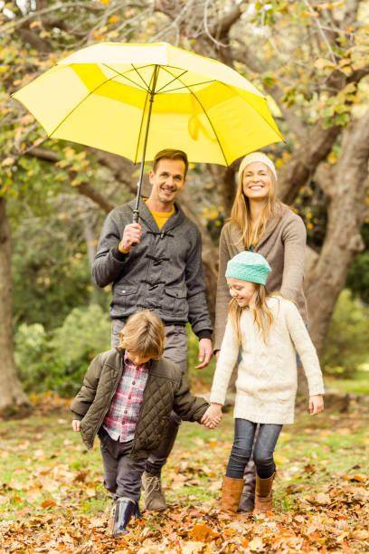 istock Smiling young family under umbrella 663902314