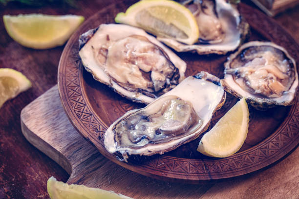 istock Oysters on plate with ice and lemon 663905512