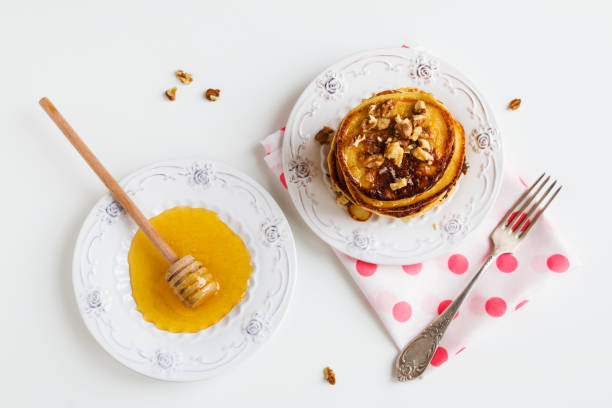 istock Homemade pancakes with honey and walnuts, vintage plate and fork 663908152