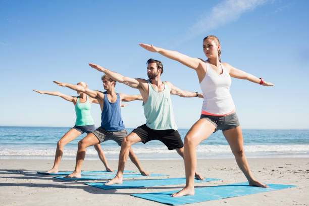 istock People doing yoga on the beach 663908764