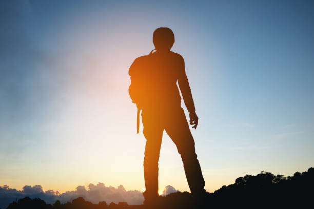 istock silhouette of Traveler man at sunset 663909304