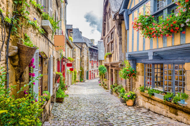 Beautiful alley in an old town in Europe Beautiful view of scenic narrow alley with historic traditional houses and cobbled street in an old town in Europe with blue sky and clouds in summer with retro vintage Instagram grunge filter effect cobblestone photos stock pictures, royalty-free photos & images