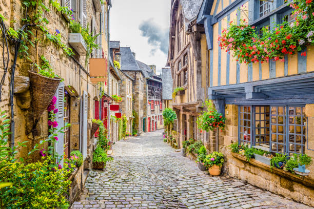 Beautiful alley in an old town in Europe Beautiful view of scenic narrow alley with historic traditional houses and cobbled street in an old town in Europe with blue sky and clouds in summer with retro vintage Instagram grunge filter effect Village stock pictures, royalty-free photos & images