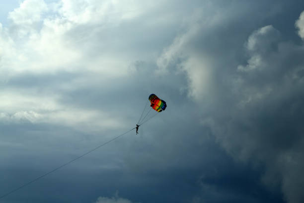 istock Parasailing on vacation over cloudy sky and sunbeam 663913154