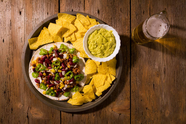 tortilhas mexicanas com carne, feijão vermelho, pimenta jalapeno, chips nachos, cerveja e salsa guacamole - chili pepper guacamole food beer - fotografias e filmes do acervo