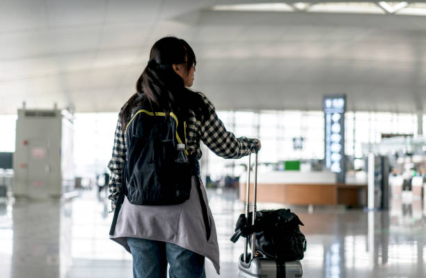 istock traveler pulling luggage in airport terminal 663916856