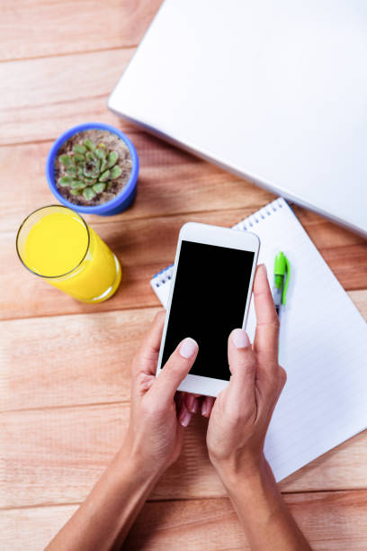 istock Overhead of feminine hands using smartphone 663923980
