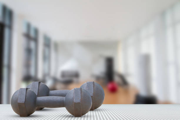 istock Dumbbells on aluminium texture floor on blurred gym background 663928878